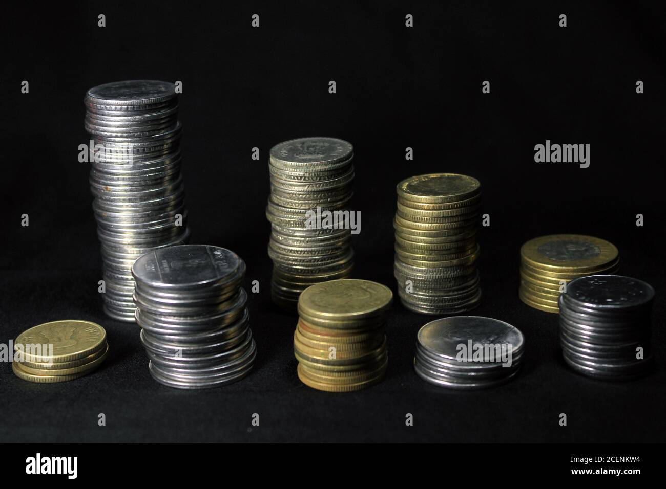 Vorratsstapel von 1, 2, 5, 10 Indische Rupie Metallmünzwährung auf schwarzem Hintergrund isoliert. Finanz-, Wirtschafts-, Investitionskonzept. Bank- und Wechselkurse Stockfoto