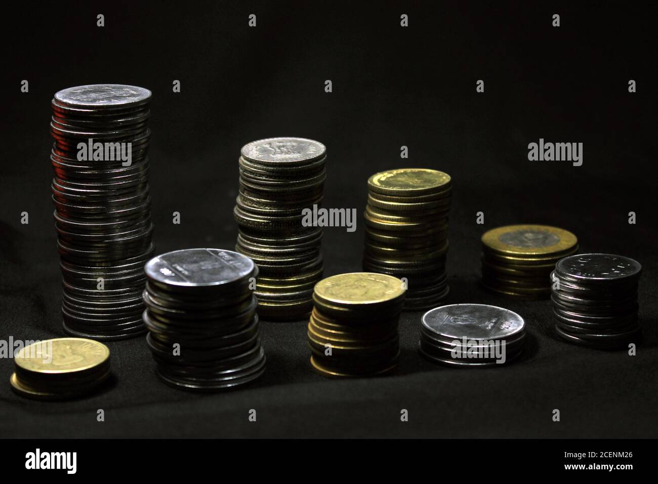 Vorratsstapel von 1, 2, 5, 10 Indische Rupie Metallmünzwährung auf schwarzem Hintergrund isoliert. Finanz-, Wirtschafts-, Investitionskonzept. Bank- und Wechselkurse Stockfoto