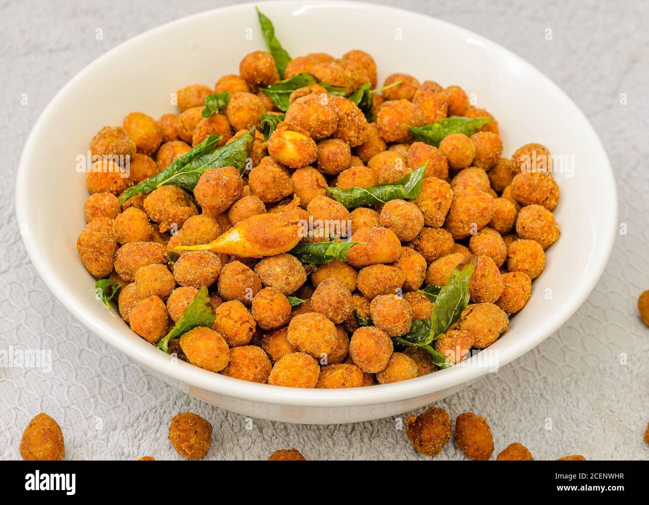 Erdnüsse in Gewürzen bedeckt tief gebratenen mit Curry Blätter und Knoblauch in einer Schüssel Stockfoto