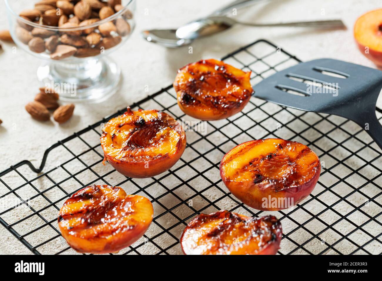Gegrillte Pfirsiche Sommer Dessert American bbq. Serviert mit Mandeln, Eis und Keksbröseln. Nahaufnahme Stockfoto