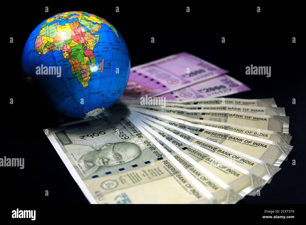 Neue indische Währung. 500 und 2000 Rupien-Noten mit Globus. Indische Währung auf schwarzem Hintergrund isoliert. Stockfoto