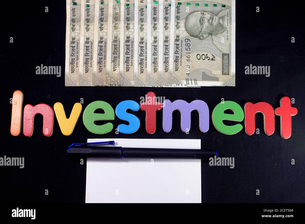 Neue indische Währung 500 Rupien-Noten. Fünfhundert Rupien indische Währung mit Stift und Notizbuch isoliert auf schwarzem Hintergrund. Investitionskonzept. Stockfoto