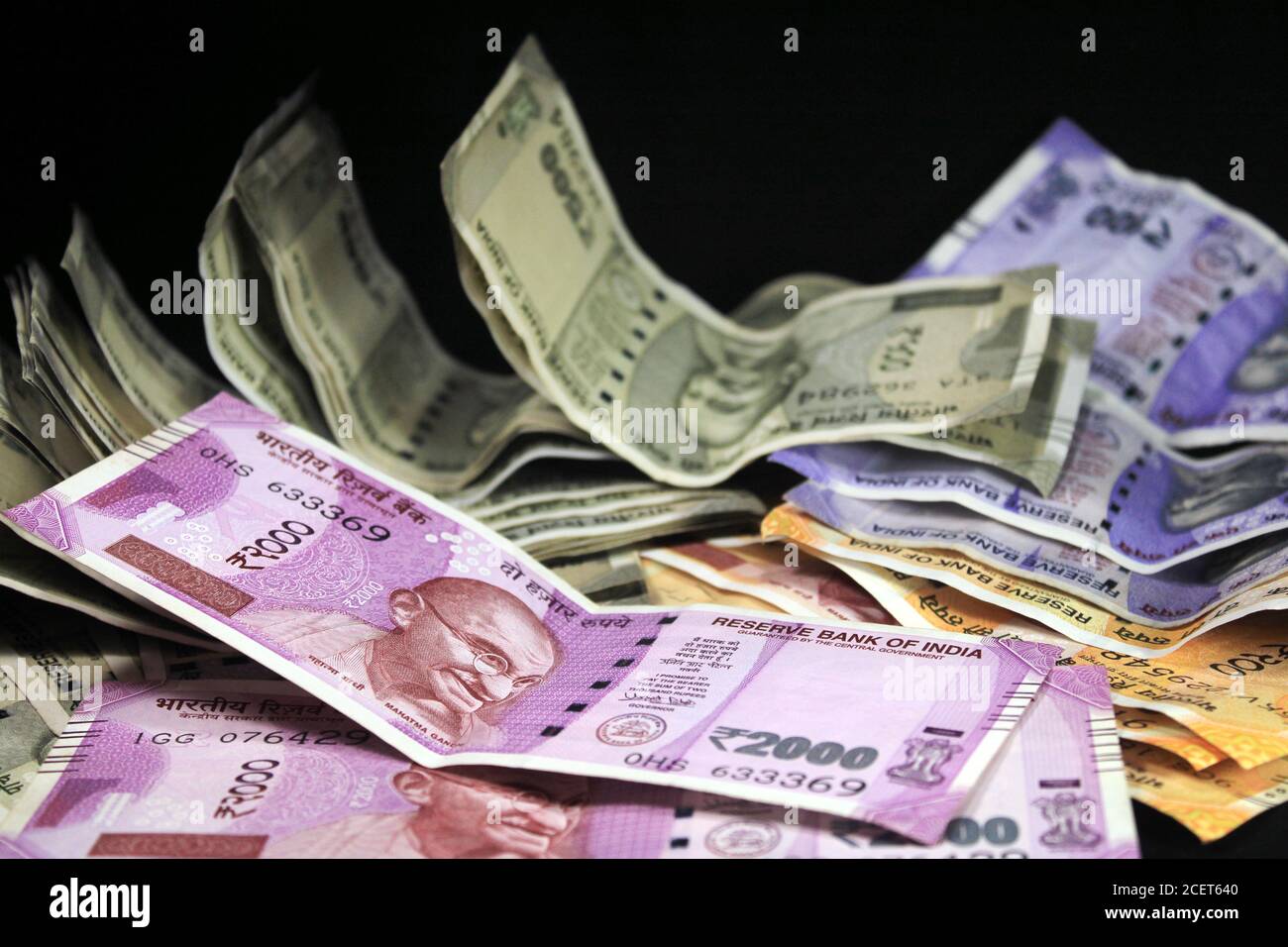 Jetzt und alte indische Währungen. 50, 100, 200, 500, 2000 Rupien-Scheine und Münzen. Indische Währung auf schwarzem Hintergrund isoliert. Stockfoto