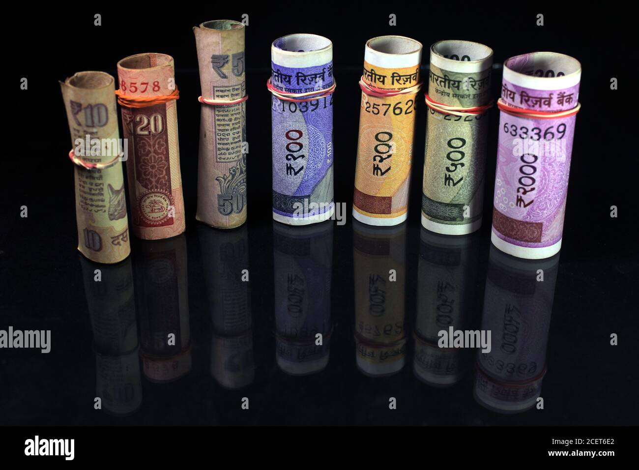 Jetzt und alte indische Währungen. 50, 100, 200, 500, 2000 Rupien-Scheine und Münzen. Indische Währung auf schwarzem Hintergrund isoliert. Stockfoto