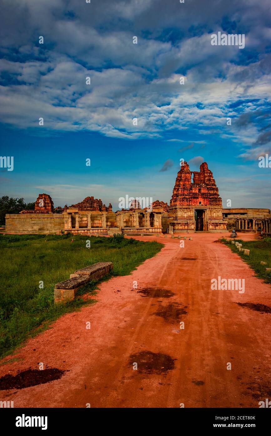 Vithala Tempel mit führenden roten Boden Straße und erstaunlichen blauen Himmel bei hampi Ruinen Bild wird bei hampi karnataka indien genommen. Es ist das eindrucksvollste und t Stockfoto