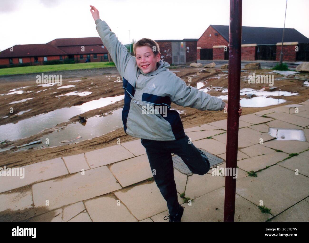 Junge spielt in der Nähe der Geschäfte auf heruntergekommenen wohnsiedlung des rates; Bradford Yorkshire Stockfoto