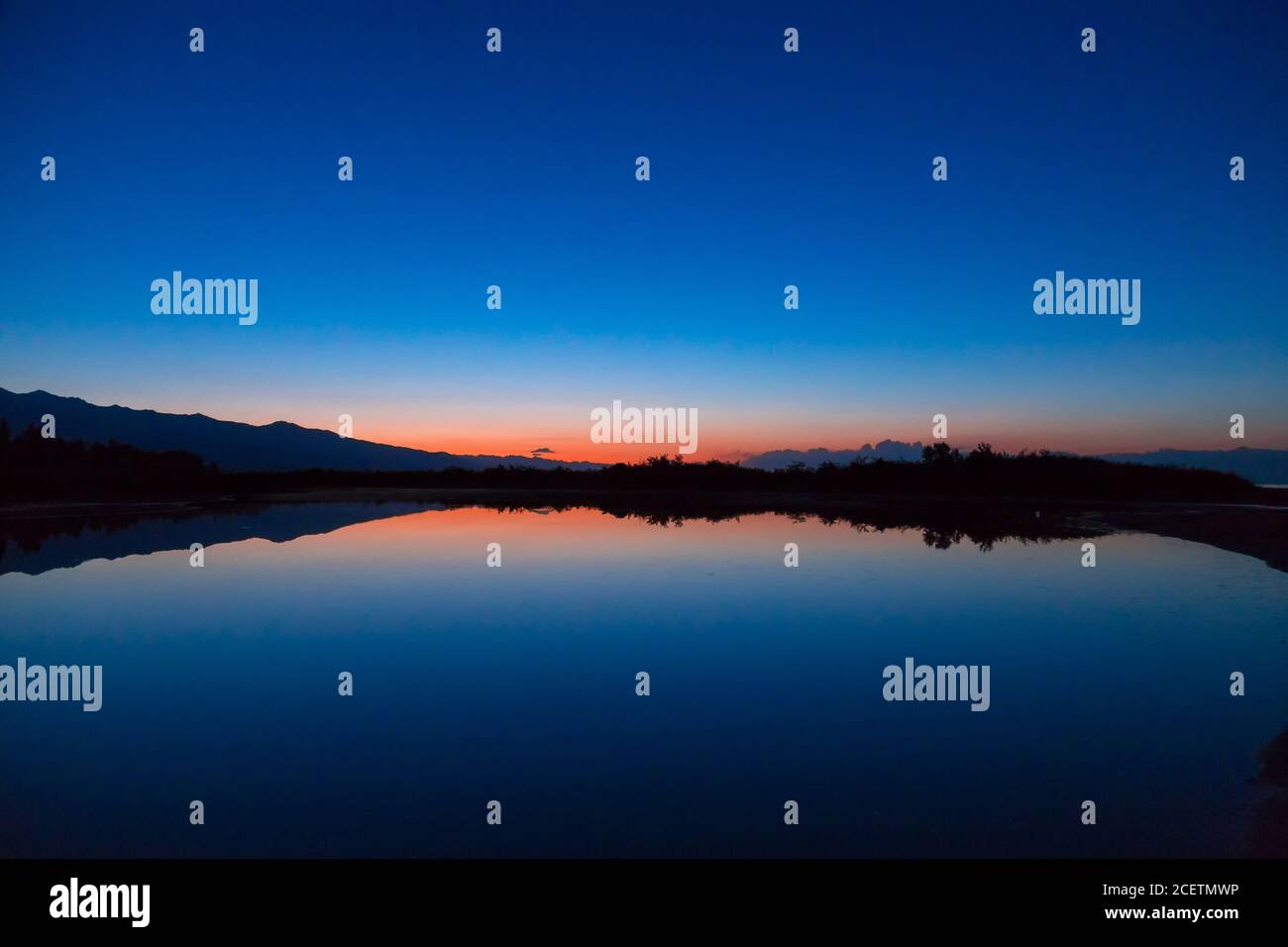 Sonnenaufgang auf dem Meer. Die aufgehende Sonne hinter den Bergen. Kirgisistan. Stockfoto