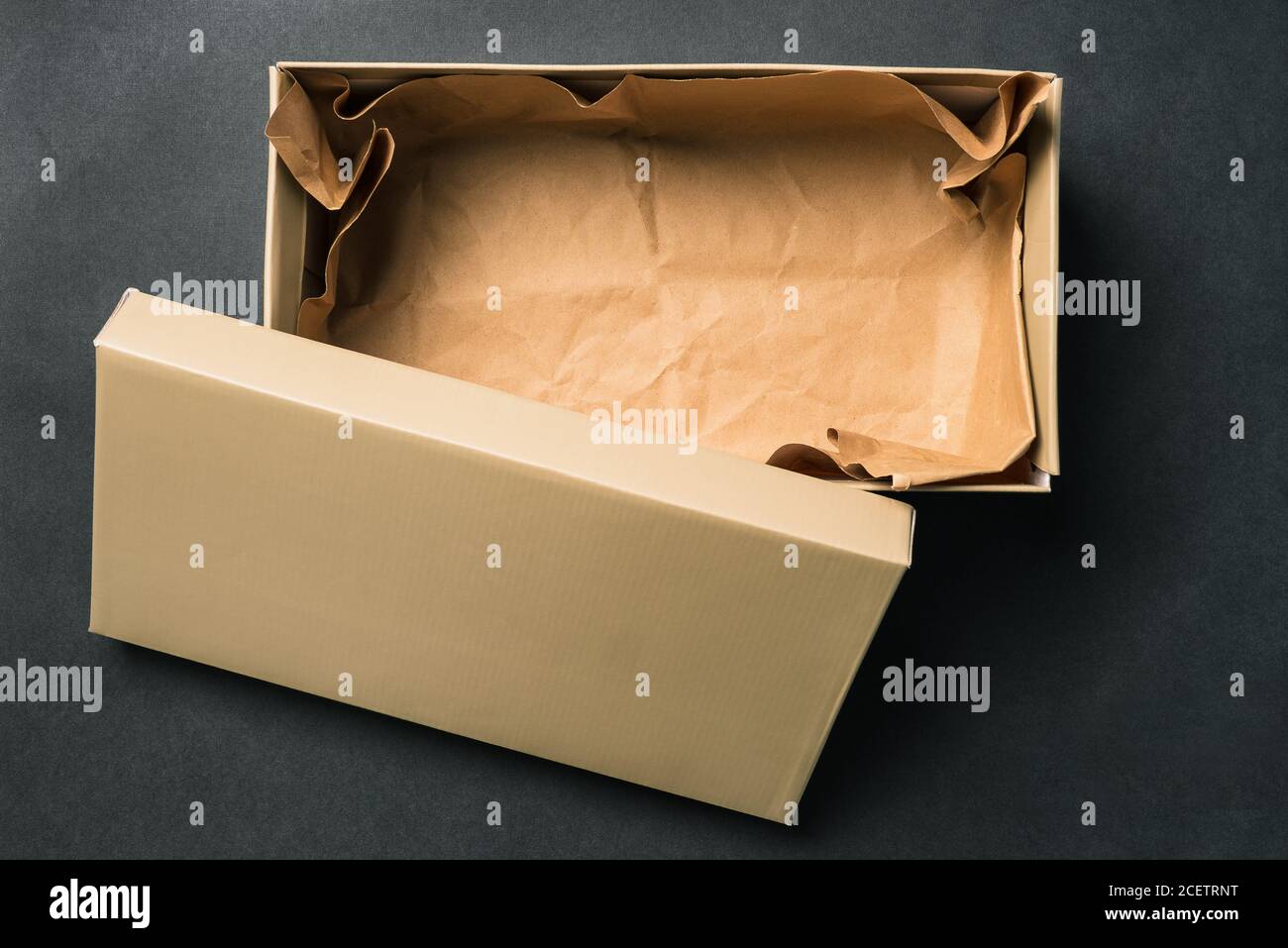 Leere Box mit Deckel öffnen, isoliert auf schwarzem Hintergrund. Karton für Schuhe oder Geschenk. Draufsicht, flaches Layout Stockfoto