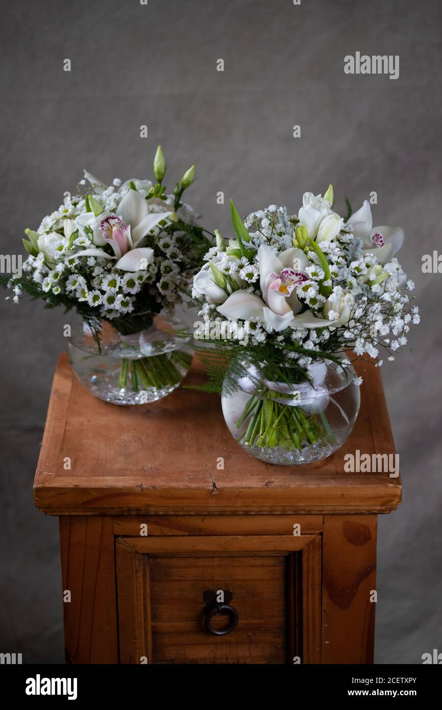 Erste heilige Kommunion Blumensträuße. Dekoriert mit Orchidee und Blumen weißen Blumen. Grauer Hintergrund Stockfoto