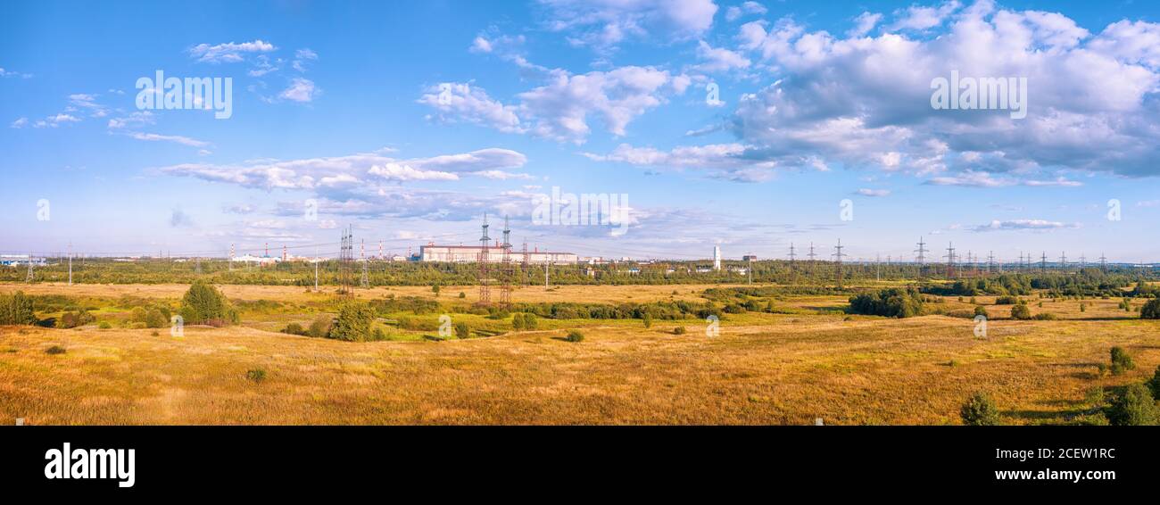 Industrielle Landschaft mit Feldern, Industriezone und Hochspannungsleitung. HDR-Panoramaansicht Stockfoto