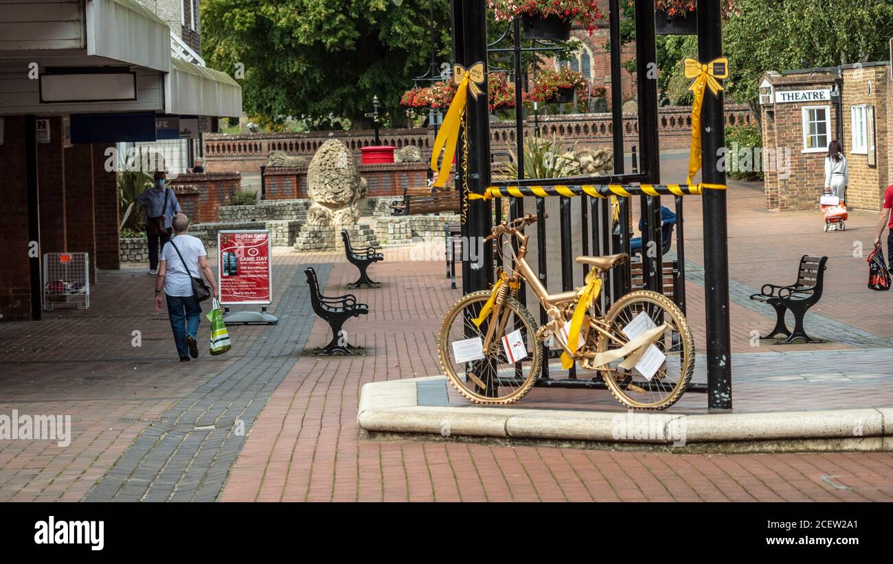 Ein Fahrrad mit Gold gesprüht wird in der Mitte einer Fußgängerzone zur Erinnerung an die Kindheit Krebs Bewusstsein Monat angezeigt. Stockfoto