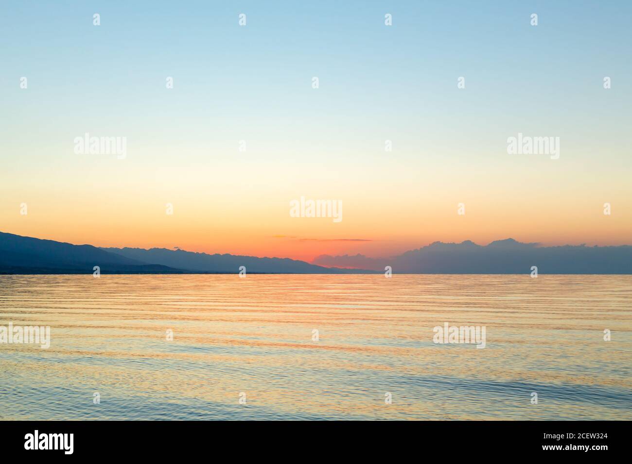 Sonnenaufgang auf dem Meer. Die aufgehende Sonne hinter den Bergen. Kirgisistan. Stockfoto