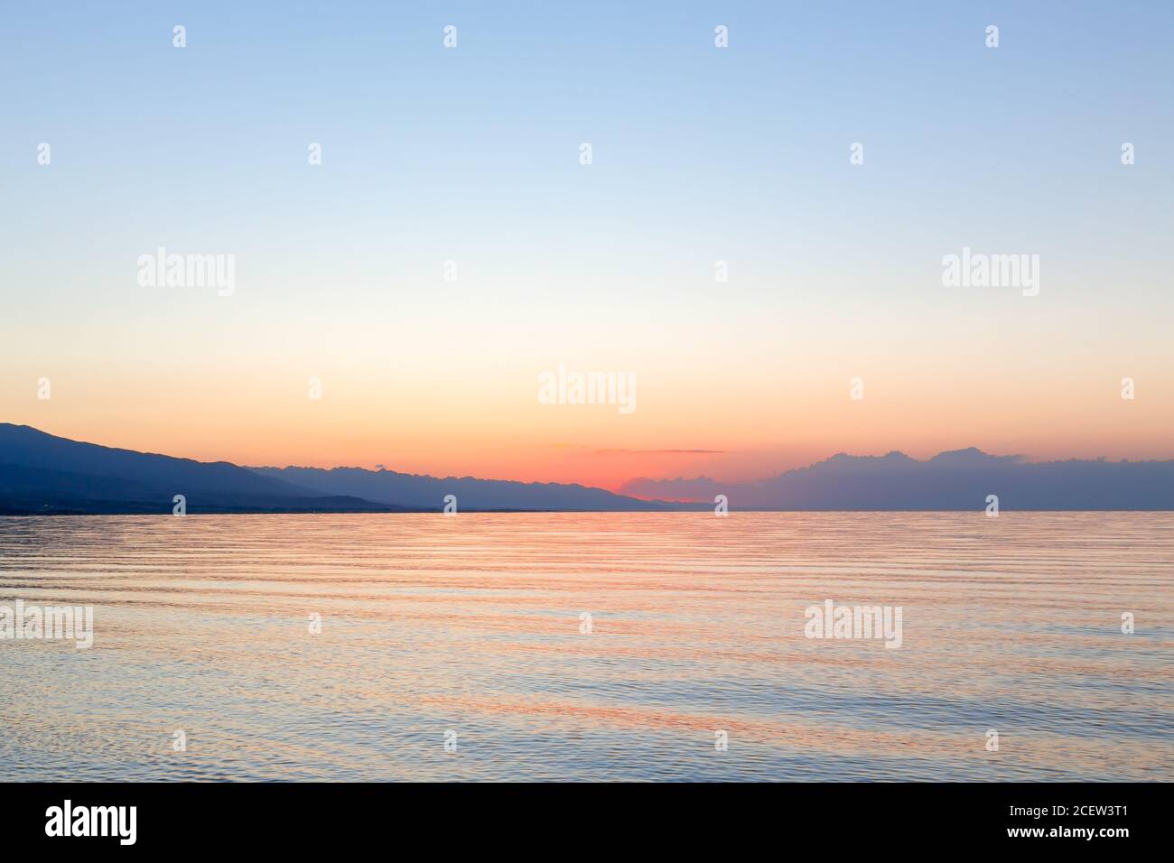 Sonnenaufgang auf dem Meer. Die aufgehende Sonne hinter den Bergen. Kirgisistan. Stockfoto