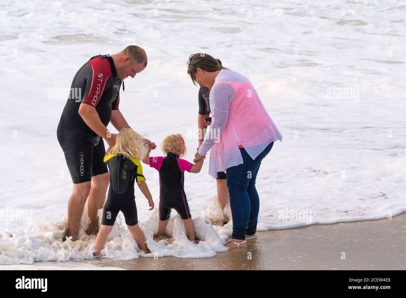 Eine Familie, die gemeinsam Spaß am Fistral Beach in Newquay in Cornwall hat. Stockfoto