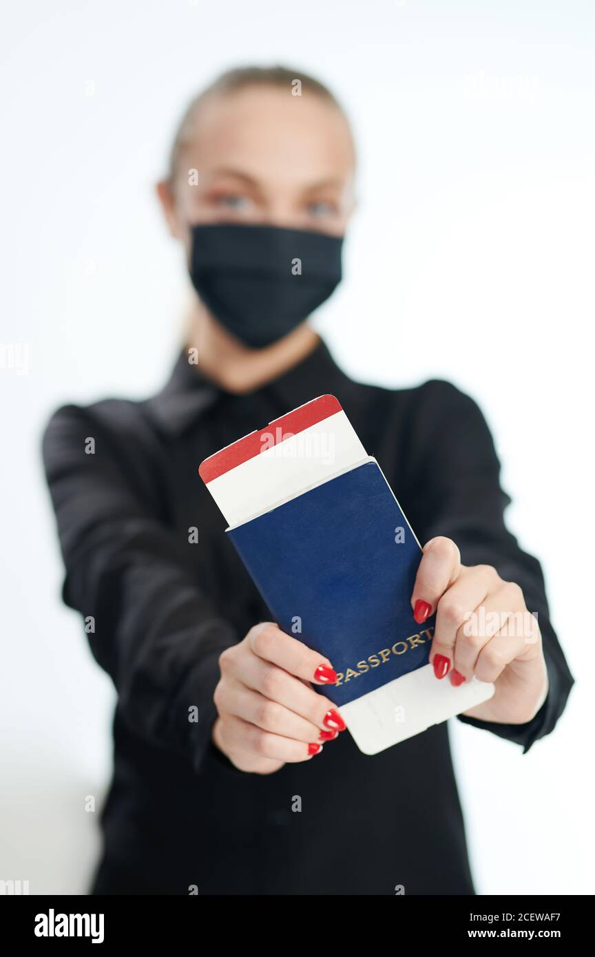 Reisepass und Flugticket in Frauenhand auf verschwommenem Hintergrund Stockfoto