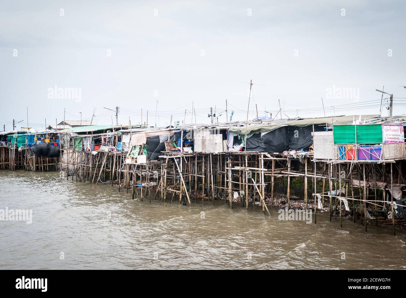 Häuser auf Stelzen Klammern sich an einen Pier am Bang Saen Beach, in der Nähe von Pattaya Thailand. Stockfoto