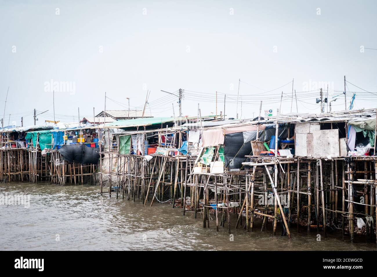 Häuser auf Stelzen Klammern sich an einen Pier am Bang Saen Beach, in der Nähe von Pattaya Thailand. Stockfoto