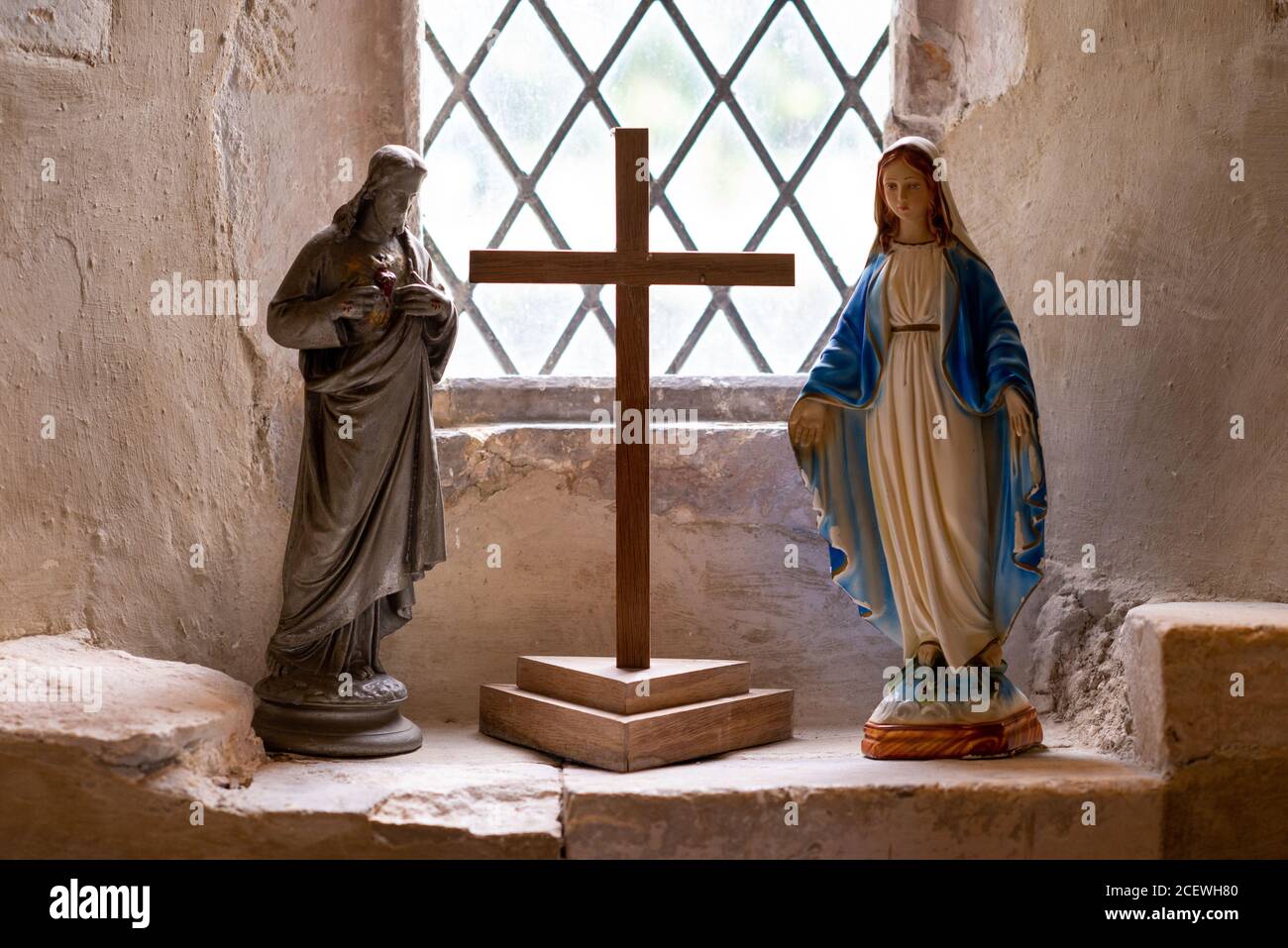 Jesus und Maria Figuren mit einem Kreuz im Fenster der Kirche St. Botolph, Botolphs auf der Route der South Downs Way, West Sussex, Großbritannien Stockfoto