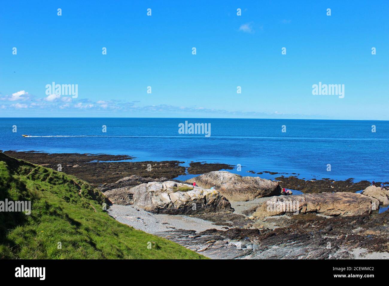 Wunderschöne Landschaft des blauen Meeres an der walisischen Küste mit einer felsigen Küste an einem sonnigen Tag in Porth Colmen, Nord Wales Stockfoto