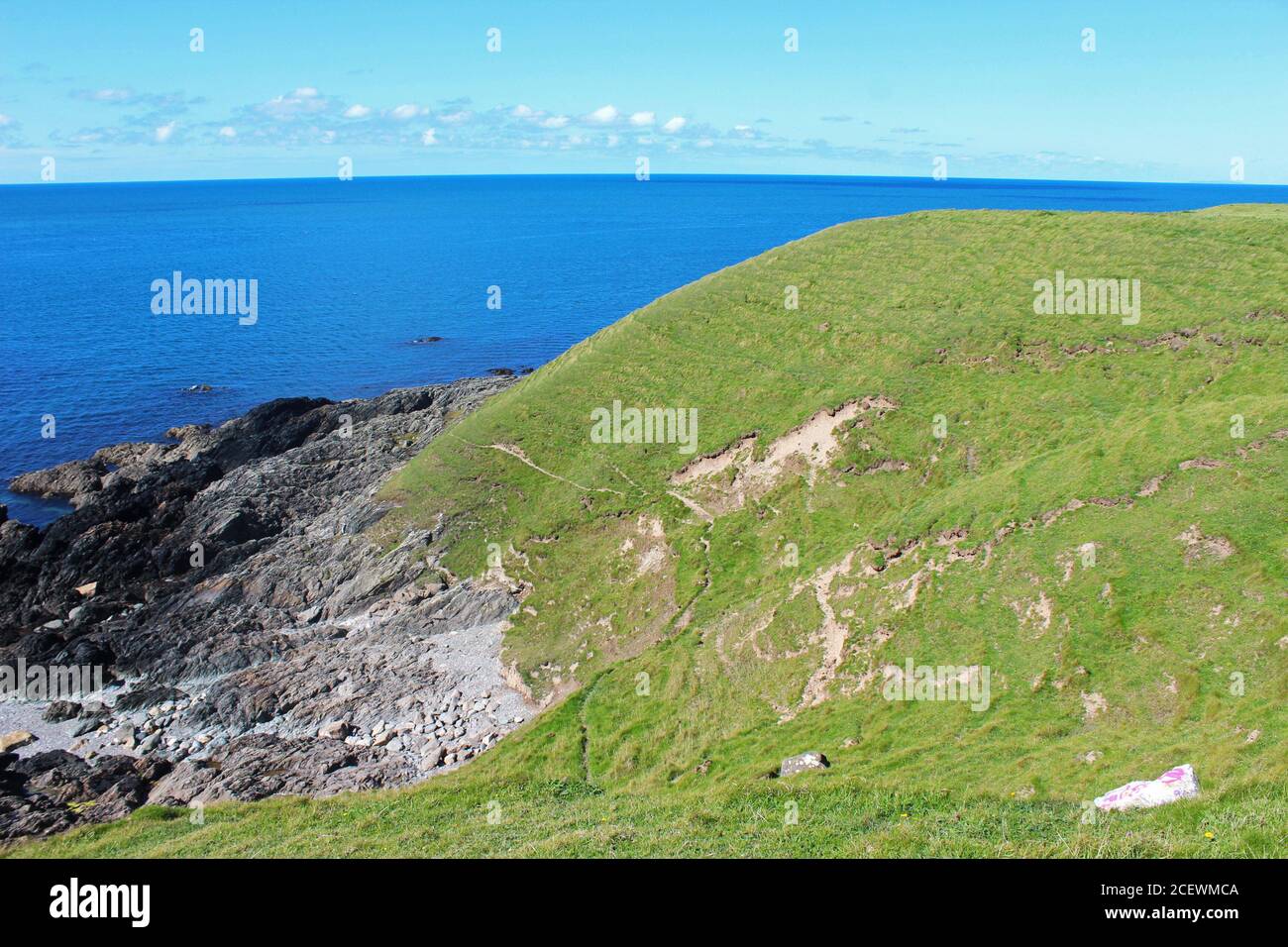Wunderschöne Landschaft an der walisischen Küste, inklusive grüner Hügel, felsiger Küste und blauem Meer in Porth Colmen, Nordwales Stockfoto Wunderschöne Landschaft an der walisischen Küste, inklusive grüner Hügel, felsiger Küste und blauem Meer in Porth Colmen, Nordwales Stockfoto