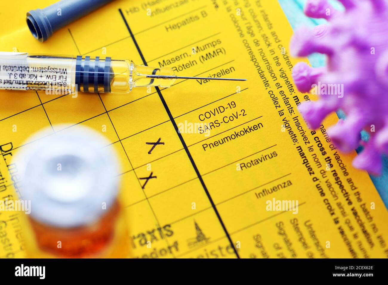 Spritze und Corona-Impfstoff auf Impfkarte, Corona-Impfung Stockfoto