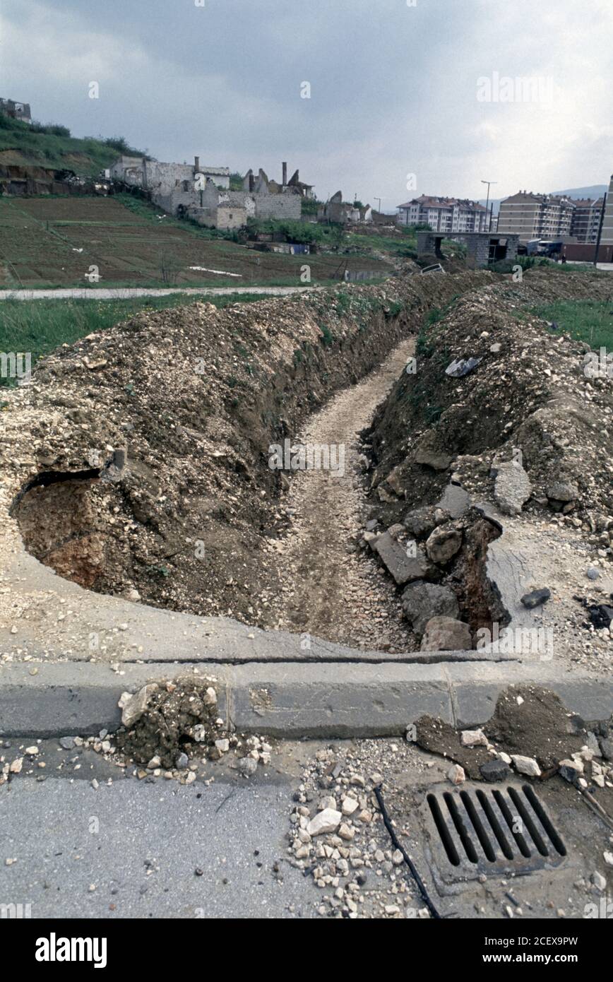 27. April 1994 während der Belagerung von Sarajevo: Ein Graben, der von bosnischen serbischen Scharfschützen bedeckt wird, führt zu den Wohnblöcken von Dobrinja, die den Hügel von Mojmilo umsäumen. Stockfoto