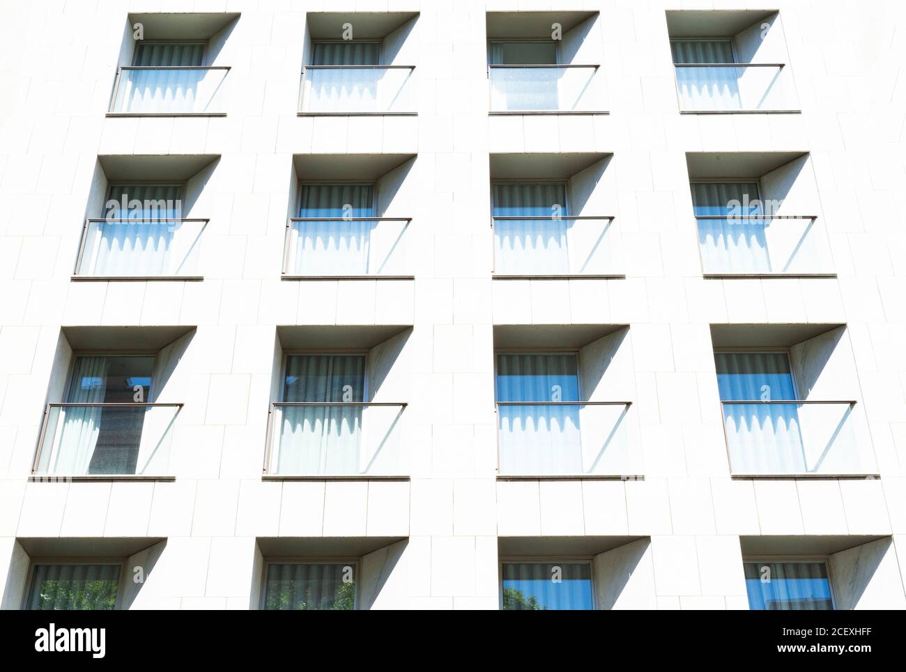 Von unten modernes Gebäude mit Glasbalkons und einfach Geometrische Fassade an sonnigen Tagen in Barcelona Stockfoto