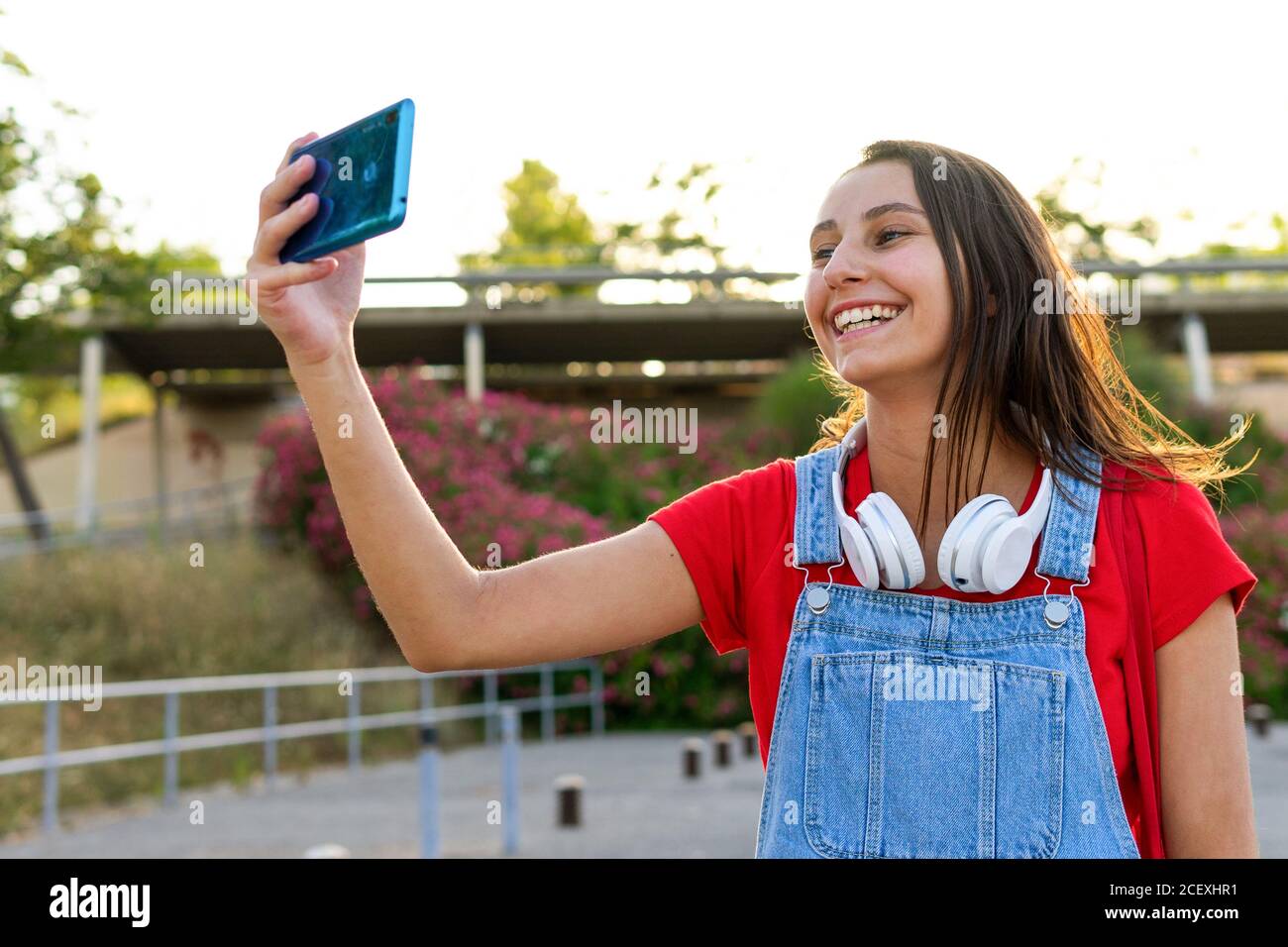 Lächelnde Frau Millennial in der Stadt stehen und fotografieren Handy Selfie-Kamera Stockfoto