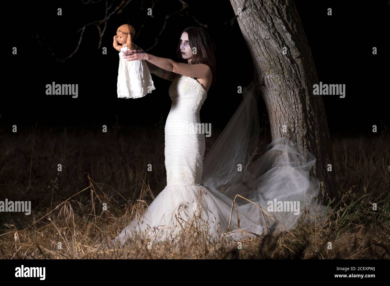 Horrorszene einer Frau, die eine Puppe hält. Hochwertige Fotos Stockfoto