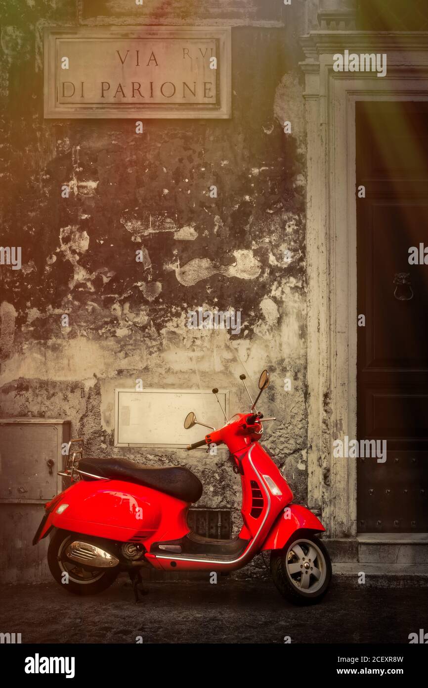 Schwarz-weiße Szene mit einem roten Roller auf einem Kopfsteinpflaster überdachte schmale Straße im Zentrum von Rom Stockfoto