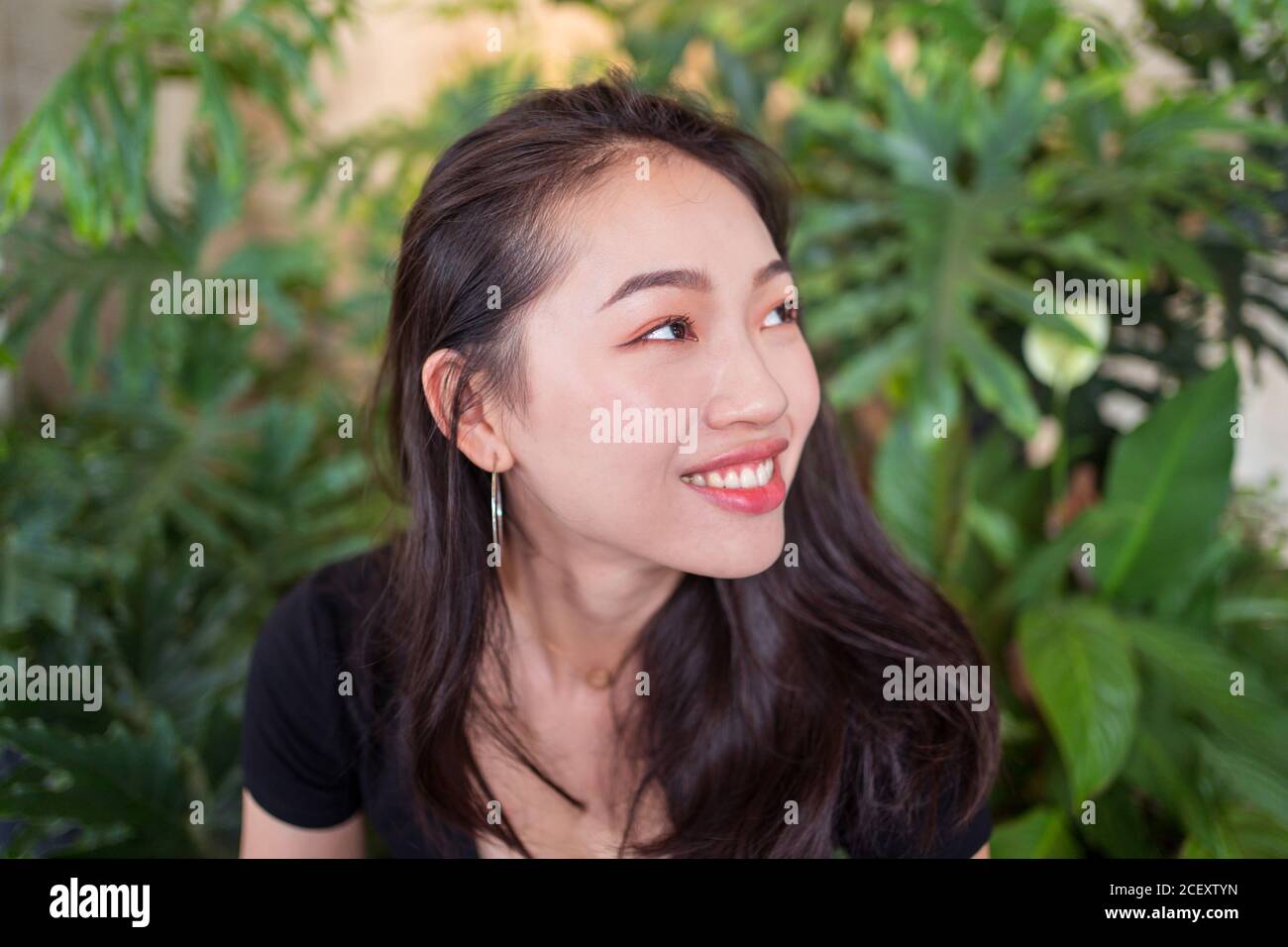 Glückliche asiatische Frau im Gewächshaus, während das Wochenende genießen und suchen Weg Stockfoto