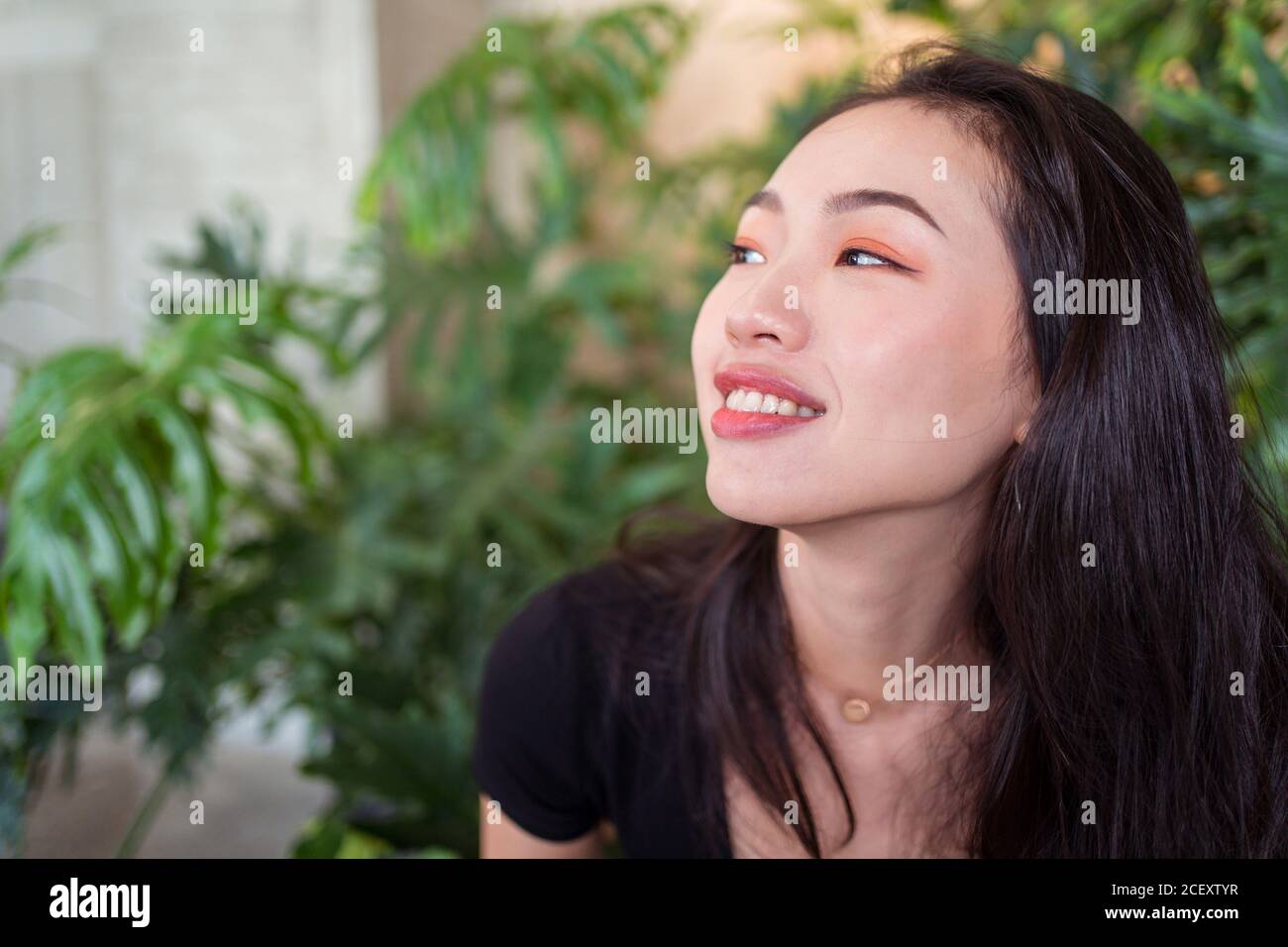 Glückliche asiatische Frau im Gewächshaus, während das Wochenende genießen und suchen Weg Stockfoto