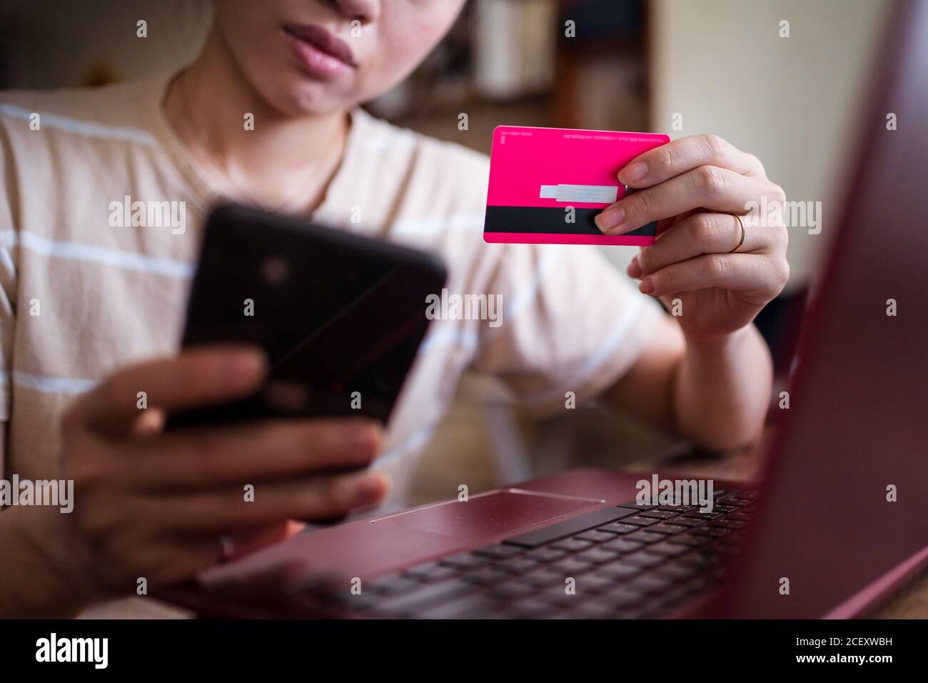 Frau sitzt am Tisch zu Hause und die Zahlung für Online-Einkäufe für Lebensmittel über die mobile App Stockfoto