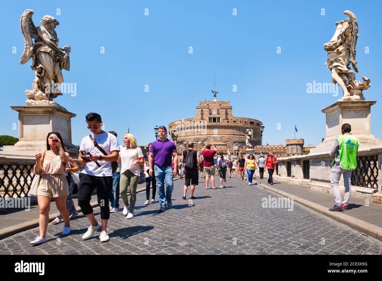 Touristen an der Ponte Sant Angelo mit der imposanten Castel Sant Angelo im Hintergrund Stockfoto