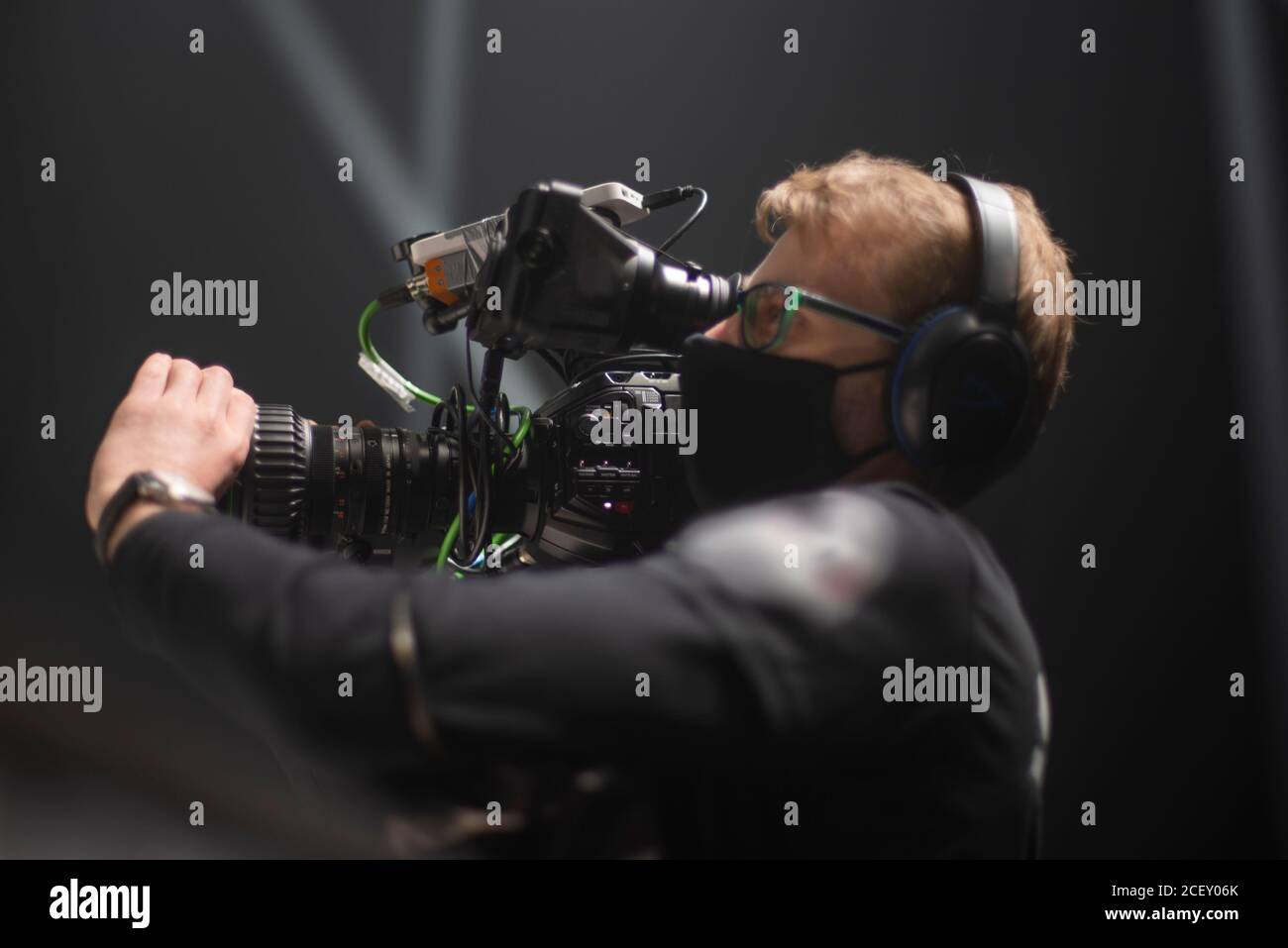 Kameramann am Set der ultimativen Kampfshow. Gegen Coronavirus maskiert Stockfoto