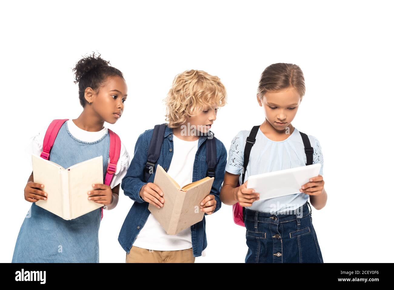 afroamerikanisch schulmädchen und blonde Schuljunge mit Bücher suchen Digitales Tablet in Händen von classmate isoliert auf weiß Stockfoto