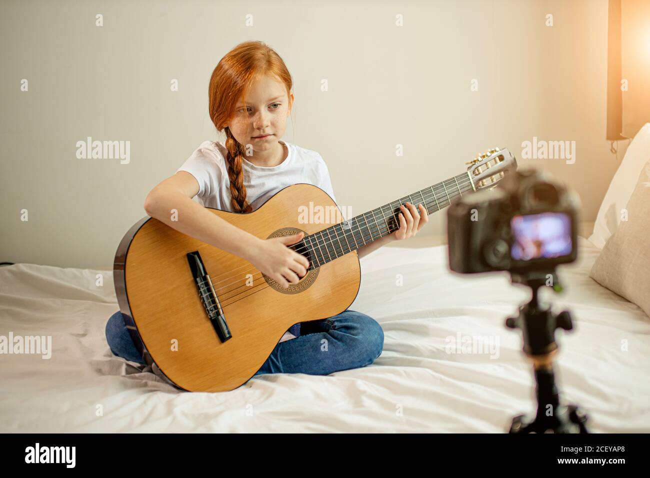 Portrait von schönen niedlichen kaukasischen Kind Mädchen blogger Gitarre spielen bei der Kamera. Liebenswert Mädchen sitzen zeigen, Durchführung neuer Melodie für Abonnenten. vl Stockfoto