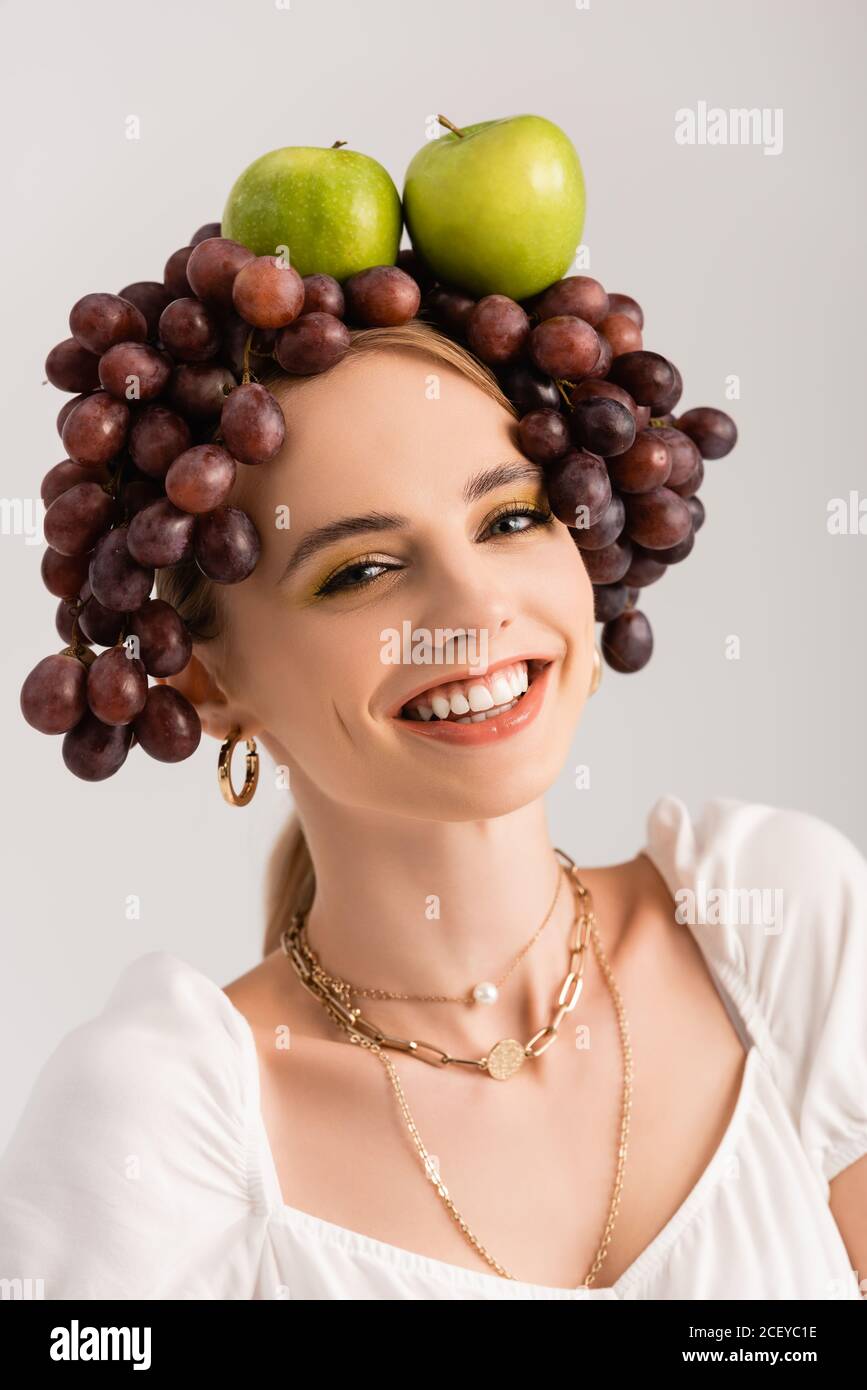 Portrait der rustikalen blonden Frau posiert mit Trauben und Äpfeln Auf ...