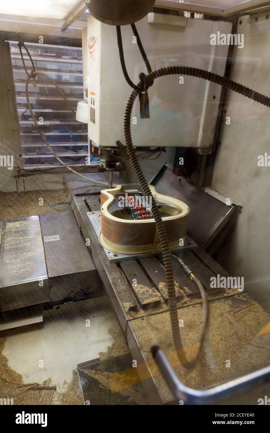 Eine computergesteuerte CNC-Präzisionsfräsmaschine schneidet eine Gitarre in der Taylor Guitar Fabrik in Tecate, Mexiko. Stockfoto