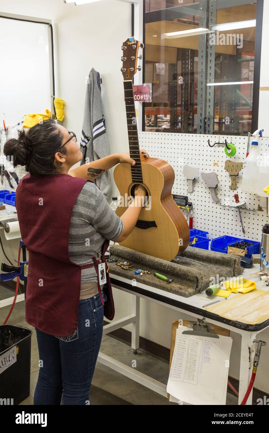 Arbeiter bauen und montieren Gitarren in der Taylor Guitar Fabrik in Tecate, Mexiko. Dieser Arbeiter befestigt den Hals am Gitarrenkörper. Stockfoto