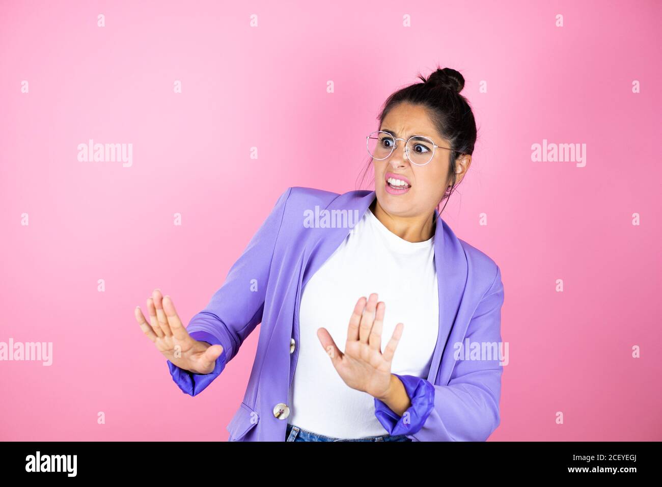 Junge schöne Geschäftsfrau über isolierten rosa Hintergrund Angst und erschrocken vor Angst Ausdruck Stop Geste mit Händen, schreien im Schock. Schwenken Stockfoto