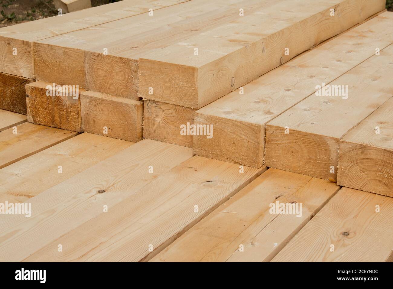Gestapelte Holzbalken. Große Holzbretter aus der Nähe. Gestapelte Holzbalken der quadratischen Sektion für den Hausbau Stockfoto