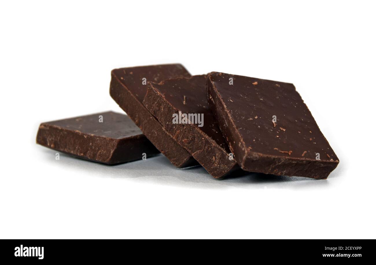 Milch- und dunkle Schokoladenwürfel. Schokoladenstapel auf weißem Hintergrund. Stapel Schokolade. Kleine dunkle Schokoladenstücke. Stockfoto
