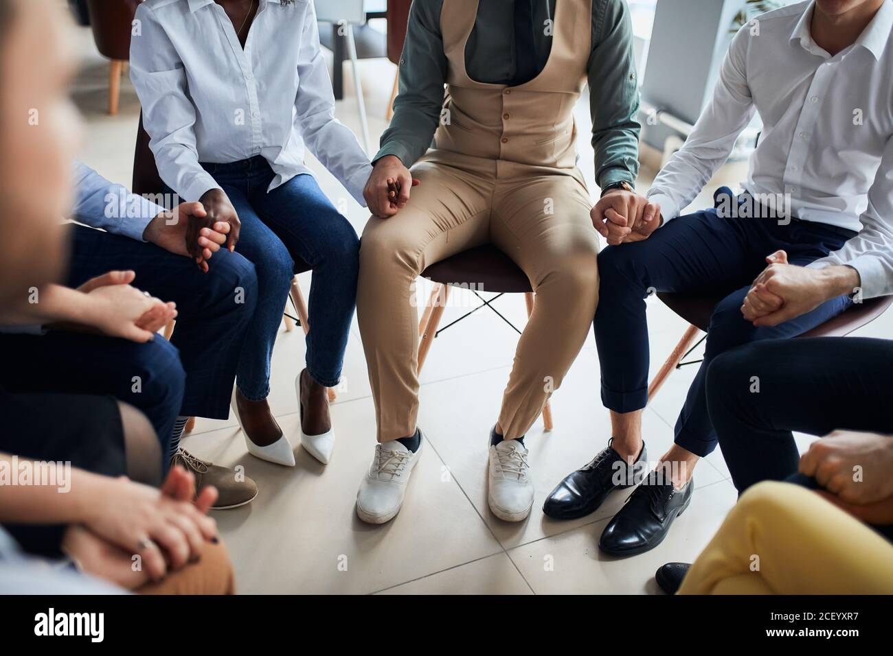 Viele Mitarbeiter versammelten sich, um für die beste Arbeit im Büro zu beten, erfolgreiche Business-Team sitzen im Kreis Stockfoto