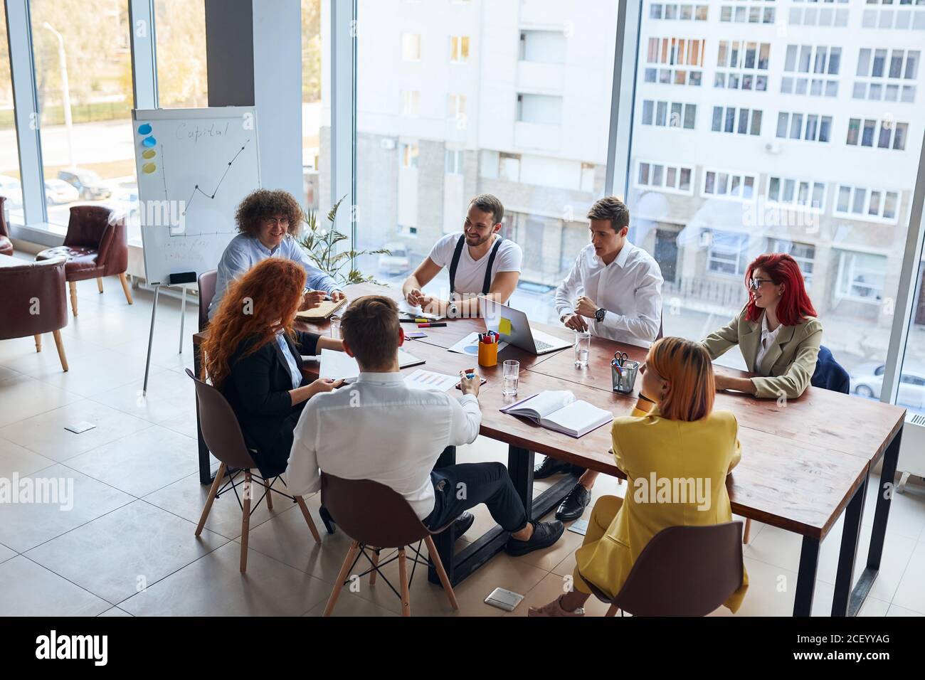 Kreative und enthusiastische Business-Gruppe sitzen im Büro zusammen arbeiten als Team, tragen formale Kleidung. Kaukasische Geschäftsleute Stockfoto