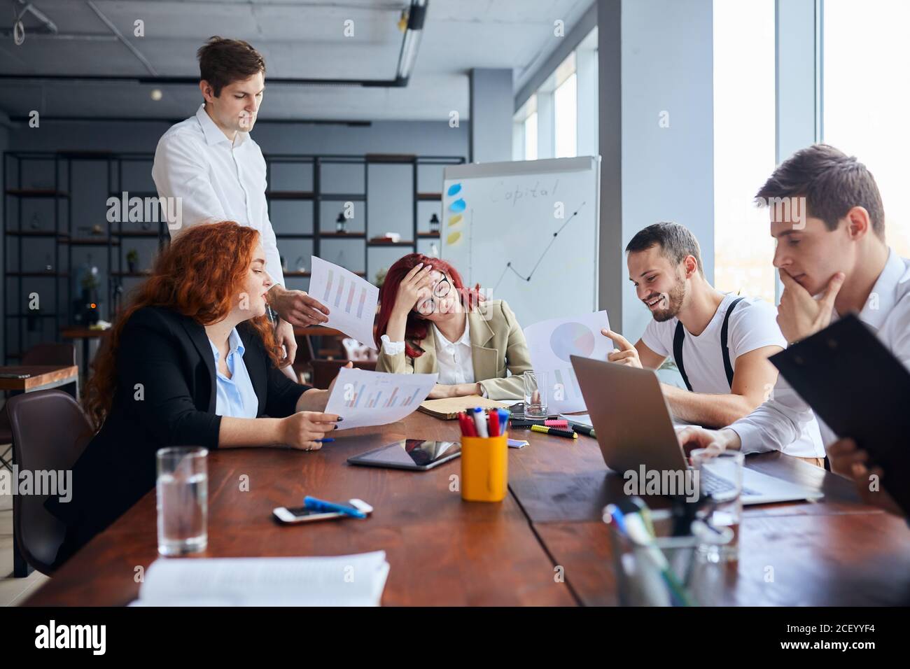 Junge Geschäftsleute traurig mit Ergebnis ihrer Arbeit, enttäuscht rothaarige Frau sitzen in der Mitte des Tisches Stockfoto