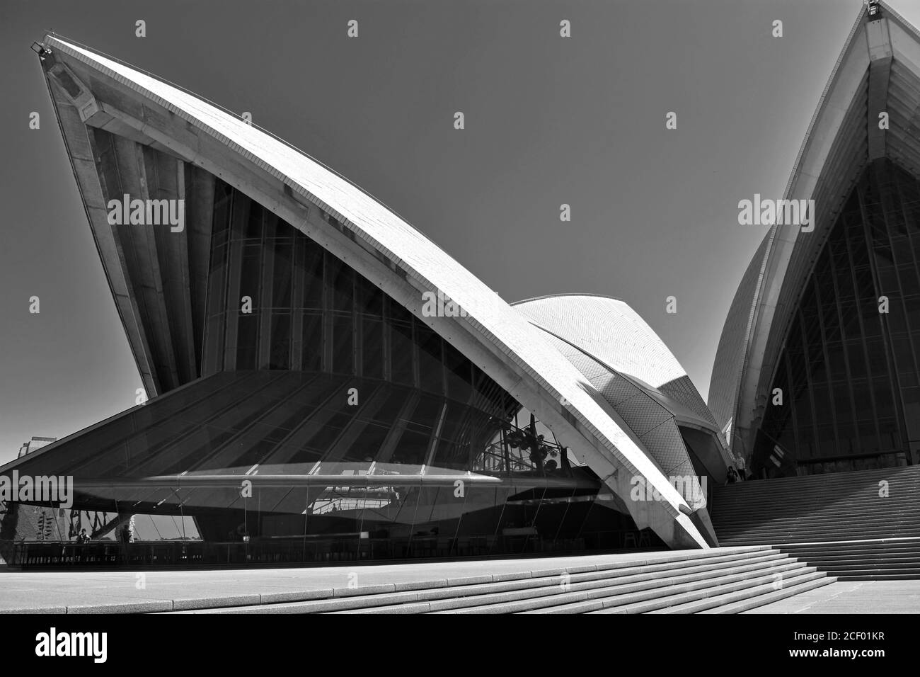 Ein abstraktes Schwarz-Weiß-Bild des Opernhauses von Sydney.die Winkel der Dachlinie und die Glasarchitektur erheben sich gegen einen klaren, grauen Himmel. Australien Stockfoto