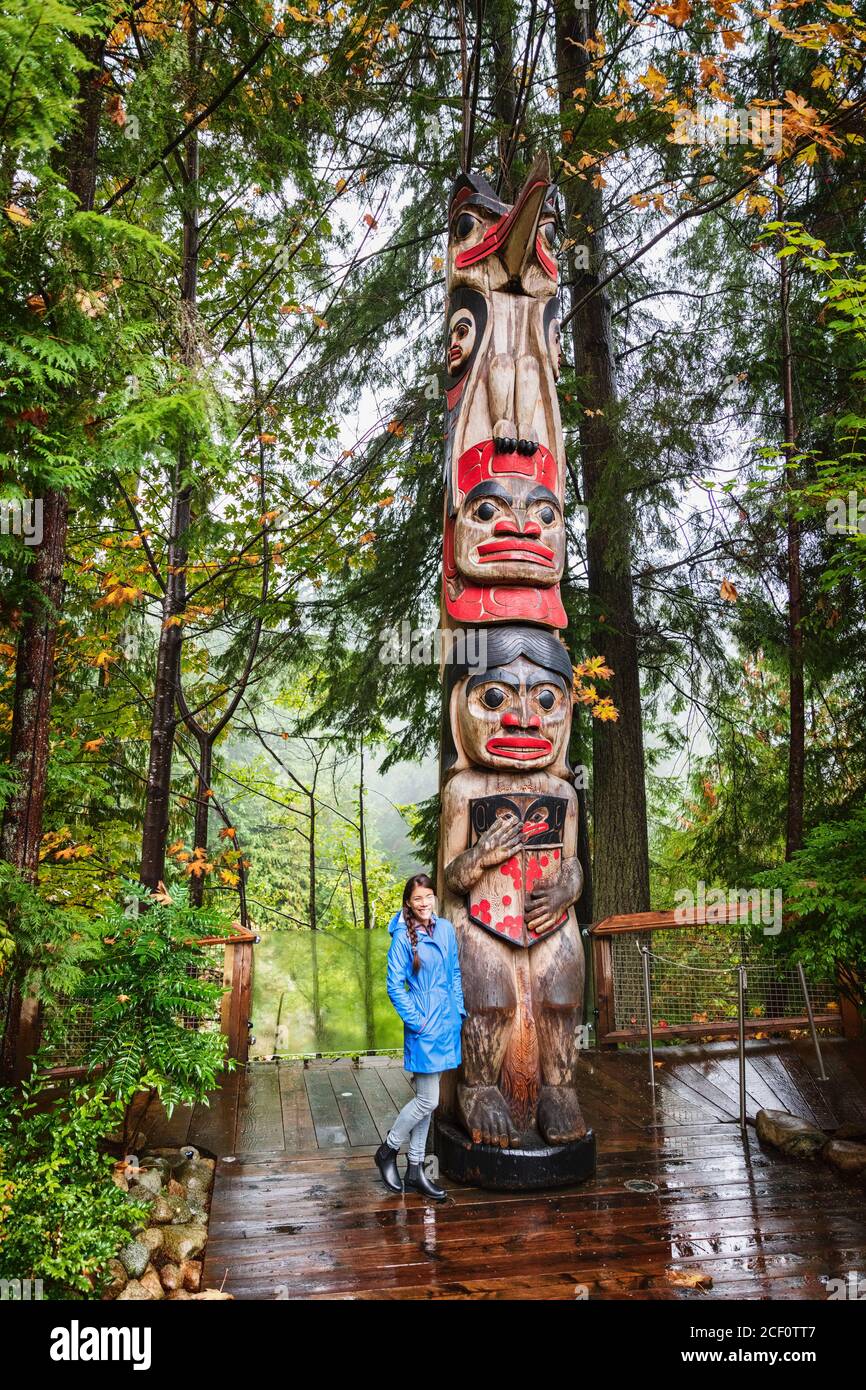 Vancouver Tourist Frau posiert von Totem Pole, British Columbia, Kanada. Asiatische Mädchen besuchen berühmte beliebte Touristenattraktion im Herbst. Stockfoto
