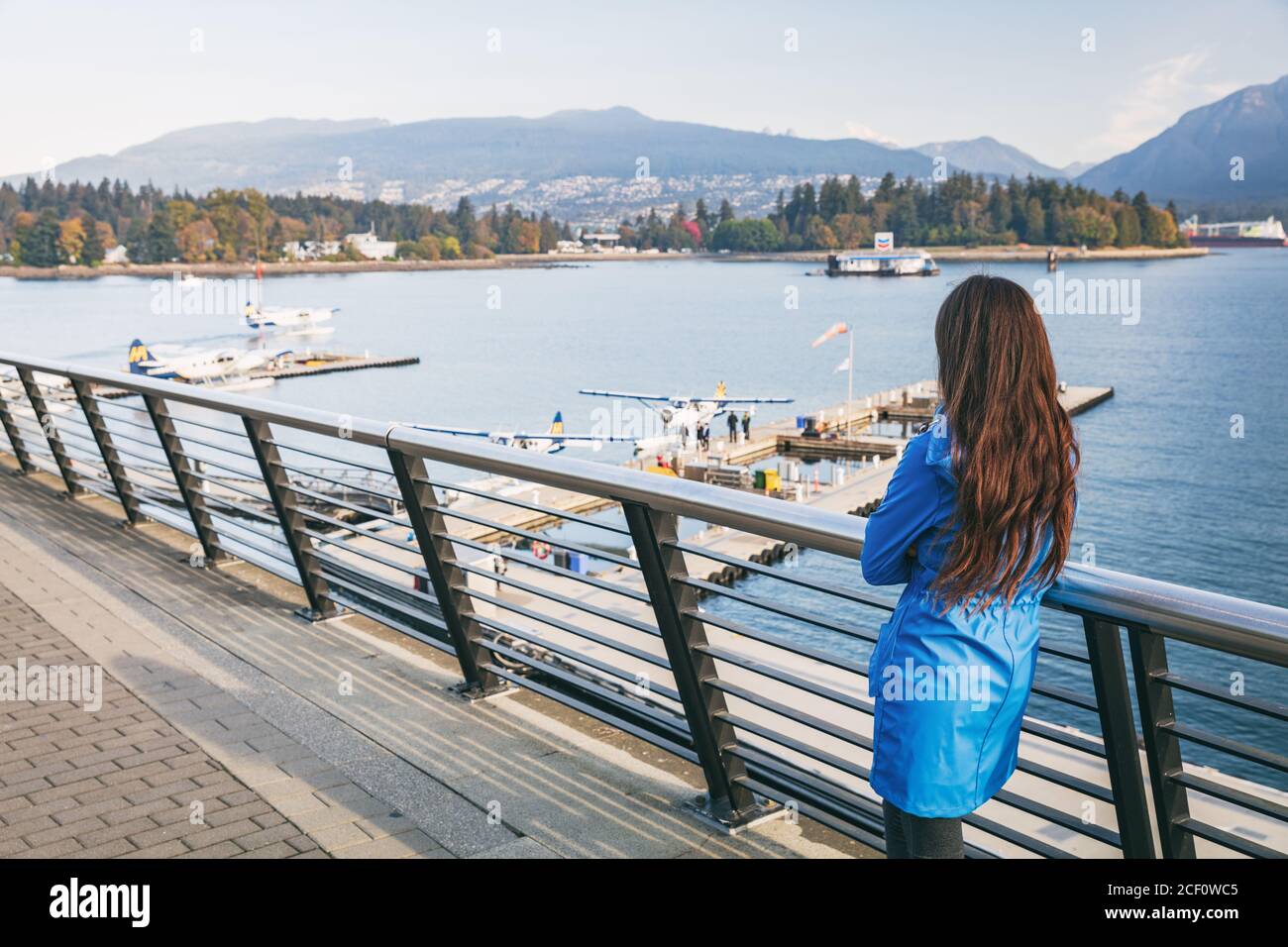 Frau zu Fuß in Coal Harbour in Vancouver City im Herbst, BC, Kanada. Reiselebensstil im Herbst. Stockfoto