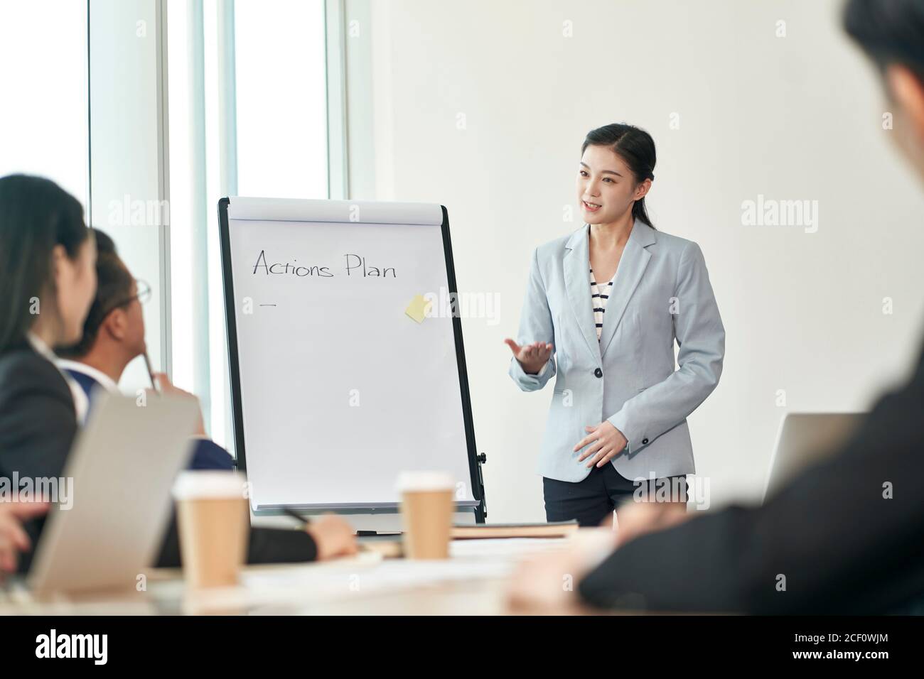 Junge asiatische Geschäftsfrau moderieren eine Diskussion während des Teamtreffens in Büro Stockfoto